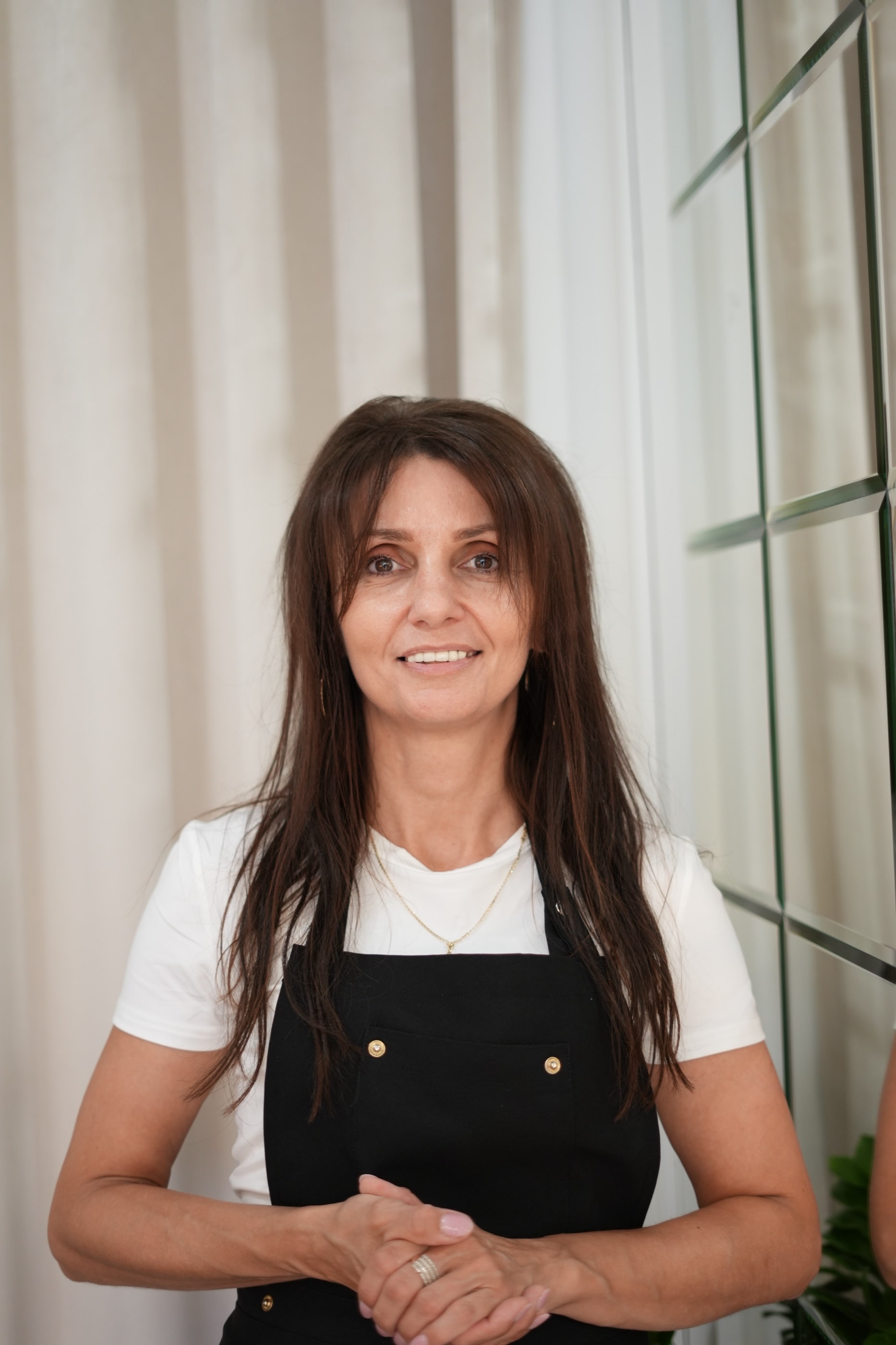 Dorota Miotk w salonie przy lustrzanej ścianie.